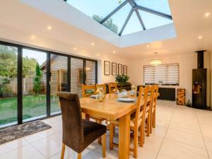 a dining room with a wooden table and chairs at 4 Bed in Aylsham 90094 in Stratton Strawless