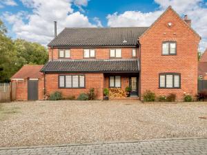 a red brick house with a gravel driveway at 4 Bed in Aylsham 90094 in Stratton Strawless