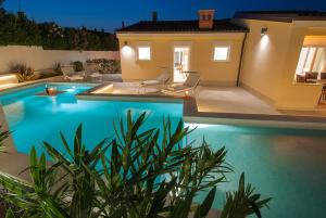 a swimming pool in front of a house at night at Villa Manuela near Medulin with private pool only 500 meters from sea in Banjole