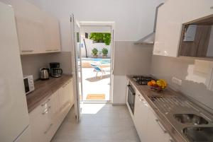 a kitchen with a sink and a stove top oven at Villa Manuela near Medulin with private pool only 500 meters from sea in Banjole