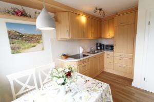une cuisine avec une table avec un vase de fleurs dessus dans l'établissement Haus Günther - Mittelweg 1, App 2, à Wenningstedt