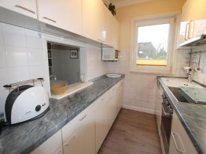 a kitchen with a sink and a counter top at Denghoog- Osetal 10, App 2 in Wenningstedt +8 photos