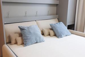Una cama blanca con dos almohadas azules. en Apartmán v meste Martin, en Martin
