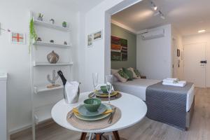 a small living room with a table and a bed at Easy Star - Apartamento Encantador ao Lado da Faria Lima - BU01H in Sao Paulo