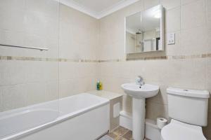 a bathroom with a sink and a toilet and a bath tub at Long Stay Heaven Penthouse Near Longcross Studios in Brookwood
