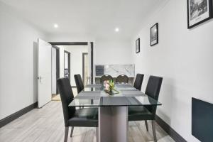 a dining room with a table and black chairs at Long Stay Heaven Penthouse Near Longcross Studios in Brookwood