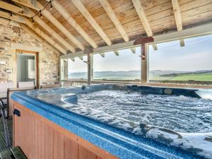 a jacuzzi tub in a room with windows at 5 Bed in Edinburgh 90141 