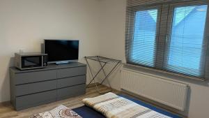 a living room with a tv on a dresser with a microwave at Milad 2xZimmerwohnung in Darmstadt