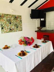 a table with a white table cloth and flowers on it at Praia de Geribá C 1 in Búzios +2 photos