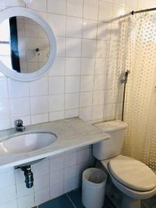 a bathroom with a sink and a toilet and a mirror at Praia de Geribá C 1 in Búzios