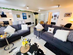 uma sala de estar com um sofá azul e almofadas brancas em Safari Lodge - Close to Shopping Centre and Restaurants, Free Parking, Stylish and Amazing Artwork em Burton upon Trent
