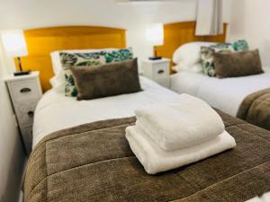 a white towel sitting on top of a bed at Safari Lodge - Close to Shopping Centre and Restaurants, Free Parking, Stylish and Amazing Artwork in Burton upon Trent