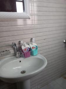 um lavatório de casa de banho com uma cesta de produtos de higiene pessoal em Prumime pyramids inn no Cairo