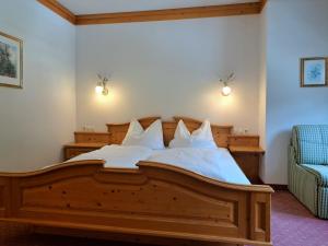 um quarto com uma cama de madeira e almofadas brancas em Appartementhaus Lackner em Grossarl