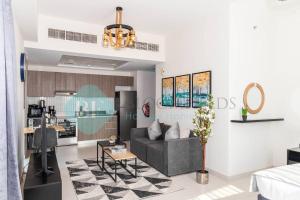 a living room with a couch and a kitchen at Spacious Studio In Raha The View in Abu Dhabi