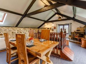 a dining room with a wooden table and chairs at 2 Bed in Polperro 90174 in Lansallos