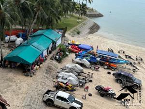 een groep voertuigen geparkeerd op een strand met boten bij New Seaview with Seaside Apartment 2 BR in Port Dickson