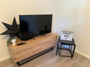 a flat screen tv sitting on top of a wooden entertainment center at Rybárny in Uherské Hradiště