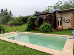 a swimming pool in a yard next to a house at Casa Madre in Villa Yacanto