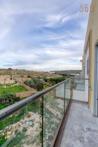 Elle comprend un balcon offrant une vue sur la campagne. dans l'établissement Lovely 3BR Apt with Private Balcony & Views in Mgarr by 360 Estates, à Mġarr