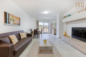 sala de estar con sofá y TV en Lovely 3BR Apt with Private Balcony & Views in Mgarr by 360 Estates en Mġarr