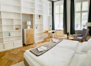 ein weißes Schlafzimmer mit einem großen Bett und einem Schreibtisch in der Unterkunft Serviced Room im Herzen Berlin‘s in Berlin