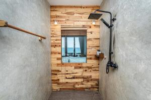 a bathroom with a wooden wall with a window at Akina Beach Resort KohLarn อกินะบีช รีสอร์ทเกาะล้าน in Ko Larn