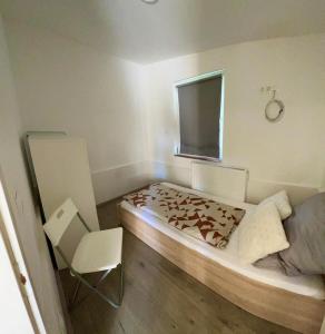a bedroom with a bed and a chair and a window at T8 BUDGET 2 Bedroom+Living room Apartment @ agglomeration Taplanszentkereszt in Szombathely