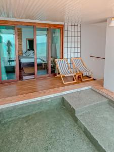 a room with two chairs and a swimming pool at Akina Beach Resort KohLarn อกินะบีช รีสอร์ทเกาะล้าน in Ko Larn