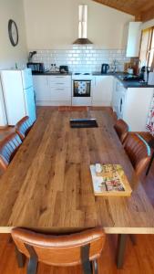 una cucina con un grande tavolo in legno con sedie di Farm lodge a Shepton Mallet