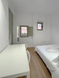 Habitación blanca con 2 camas y mesa en SD Habitación céntrica con baño y minicocina, en Terrassa
