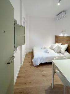 SD Habitación céntrica con baño y minicocina في تيراسا: غرفة نوم بيضاء مع سرير وطاولة