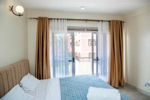 a bedroom with a bed and a large window at FG Homestay, Kampala Muyenga-Bukasa in Kampala