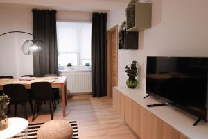 ein Wohnzimmer mit einem Esstisch und einem TV in der Unterkunft Forest View Apartment in Jáchymov