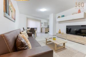 sala de estar con sofá, TV y mesa en Lovely 3BR Apt with Private Balcony & Views in Mgarr by 360 Estates en Mġarr