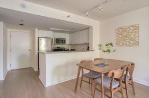 a kitchen and dining room with a wooden table and chairs at South Beach 1br w on-site shops restaurants SFO-1659 in San Francisco