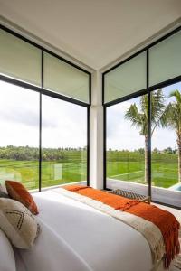 a bedroom with a bed and a large window at NEW Luxury 3BR, Jacuzzi Rooftop Rice Field, Staff in Legian