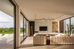 a living room with a couch and a television at NEW Luxury 3BR, Jacuzzi Rooftop Rice Field, Staff in Legian