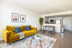 a living room with a yellow couch and a table at South Beach 1br across the street from SF bay SFO-1661 in San Francisco