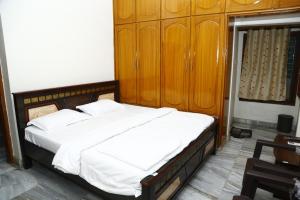 een slaapkamer met een groot bed en houten kasten bij Sri Naari inn in Kondavīdu