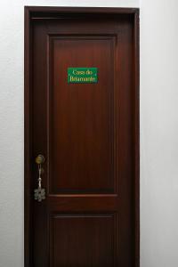 una puerta de madera con una señal verde. en Casa do Briamante 6, en Sintra