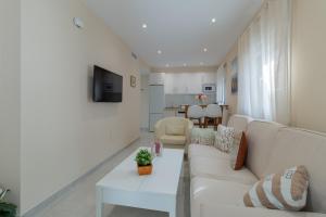 uma sala de estar com um sofá branco e uma mesa em Luxury El Patio de la Judería em Córdoba