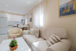 un soggiorno con divano bianco e tavolo di Luxury El Patio de la Judería a Cordoba