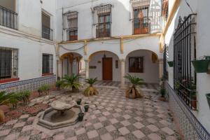 a courtyard in a building with a fountain at Luxury El Patio de la Judería in Córdoba