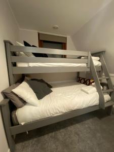 a bunk bed in a room with white pillows at The Triangle Lodge in Invergarry