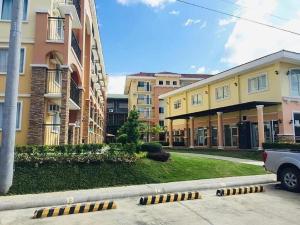 eine Reihe von Gebäuden auf einer Straße mit einem Parkplatz in der Unterkunft Arezzo Place Davao Condominium in Davao City