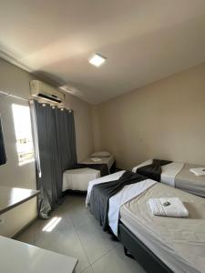 Habitación de hotel con 2 camas y ventana en Casa Lua, en Brumadinho