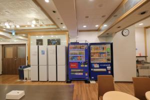 Cette chambre comprend un réfrigérateur et une horloge murale. dans l'établissement Guest House Umikaji, à Naha