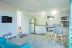 a kitchen with a table and chairs and a refrigerator at Leu Jardin in Saint-Leu