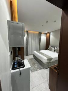 um quarto de hotel com uma cama e uma televisão em أجنحة العلمين em Tabuk